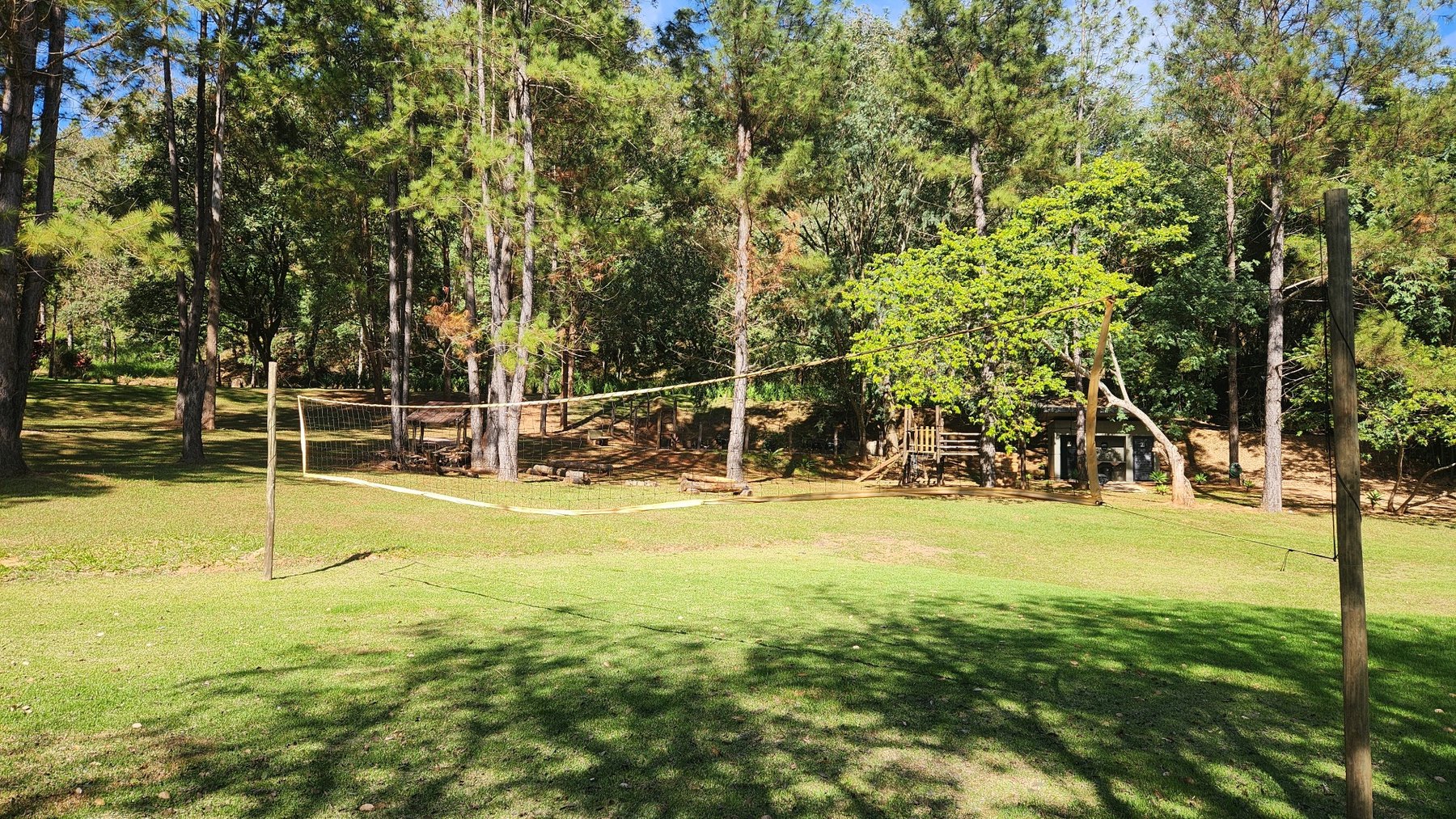 Quadra de vôlei cercada por área verde no condomínio